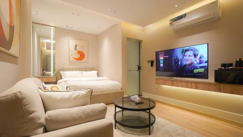 QuaiLuxe Haven Studio Comfort near Boulevard111的客厅里有一张沙发，墙上有一台电视