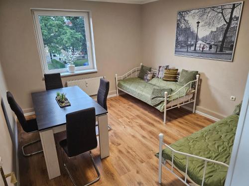 a living room with a dining room table and a bedroom at Seegarten in Görlitz