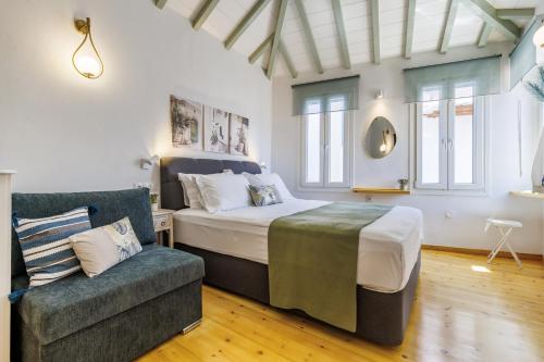 a bedroom with a bed and a couch at Maritina Skopelos Maisonette in Skopelos Town