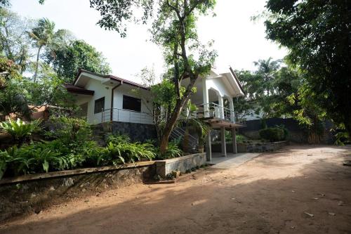 a white house with a tree in front of it at Brescia villa - Your Private Escape in matara in Gandara West