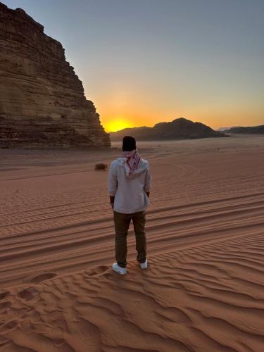 a man standing in the desert watching the sunset at Abdo waid rum in Aqaba