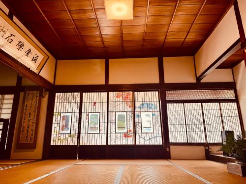 a room with doors and windows in a building at 稲花 TŌKA Stay&Retreat Sauna,Guided Tours & Farm Life with Animals in Kitsuki
