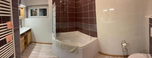a bathroom with a tub and a toilet and a sink at Chambres BB A Coste in Couloumé-Mondébat