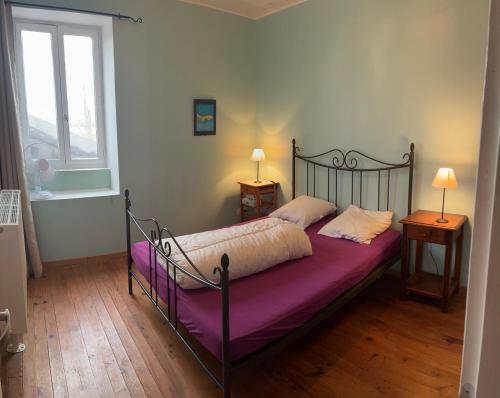a bedroom with a bed with purple sheets and a window at Chambres BB A Coste in Couloumé-Mondébat