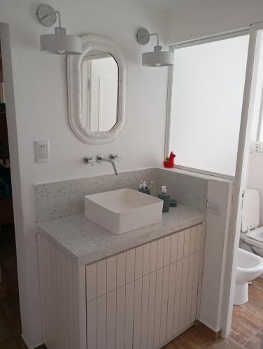 a bathroom with a sink and a mirror at Casa para disfrutar en Necochea 5 personas in Necochea