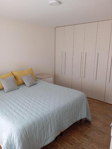 ein Schlafzimmer mit einem großen weißen Bett und weißen Schränken in der Unterkunft Casa para disfrutar en Necochea 5 personas in Necochea