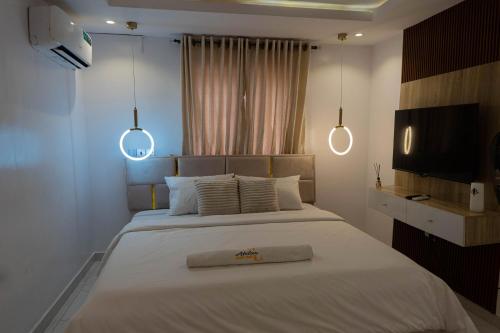 1 dormitorio con 1 cama grande con 2 luces. en Atelier Lux Homes- Modern Service Apartments with Amazing Designs, en Ibadán