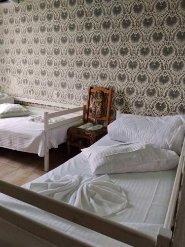 two beds in a bedroom with a wall at Готель Колізей in Khmelnytskyi