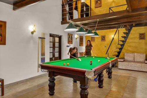 Dos mujeres jugando al billar en una habitación con mesa de billar en The Tusker's Hideout, en Alawwa