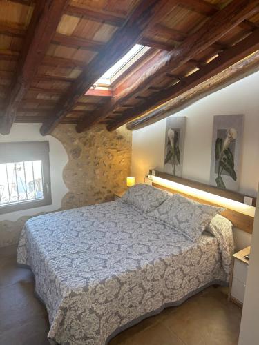 a bedroom with a bed in a stone wall at Casa Inés in Penáguila