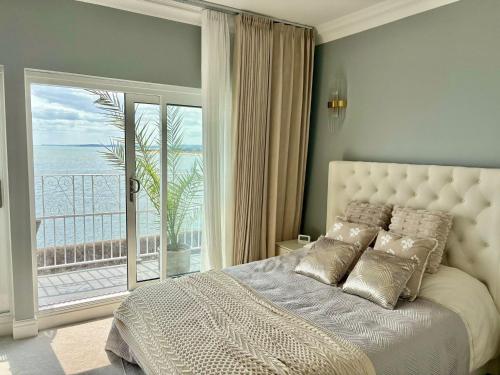 a bedroom with a bed with a view of the ocean at York House in Exmouth