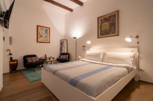 a bedroom with a large bed and two chairs at The Luxury Roma Amor in Rome