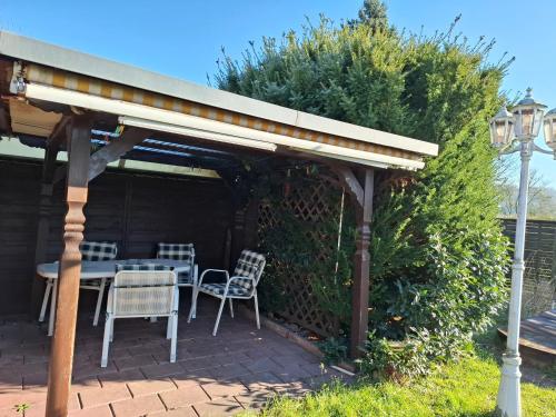 un patio avec une table et des chaises sous un pavillon dans l'établissement Monteurzimmer, Monteurunterkunft in 20 km von Hanau und 35 km von Frankfurt am main, à Florstadt