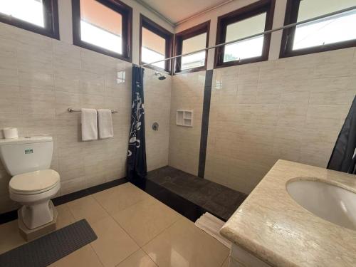 a bathroom with a toilet and a sink and a shower at Villa Rob in Kerobokan