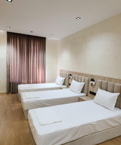 Horizon Hotel في طشقند: صف من ثلاث اسره في غرفه الفندق