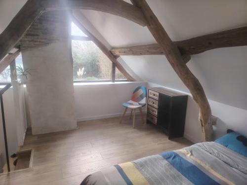 ein Schlafzimmer mit einem Bett, einer Kommode und einem Fenster in der Unterkunft Maisonnette au calme 