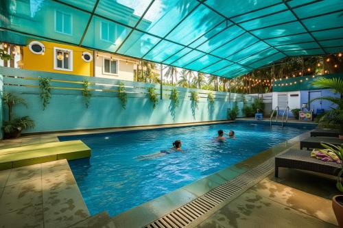 un gruppo di persone che nuotano in una piscina di FabHotel Bagatel a Calangute