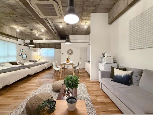 a living room with two beds and a table in it at b hotel Nikke - 1BR Apt for 10ppl near Hondori Shopping in Hiroshima