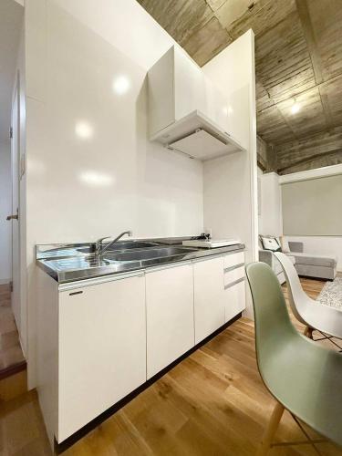 a white kitchen with a sink and a chair at b hotel Nikke - 1BR Apt for 10ppl near Hondori Shopping in Hiroshima