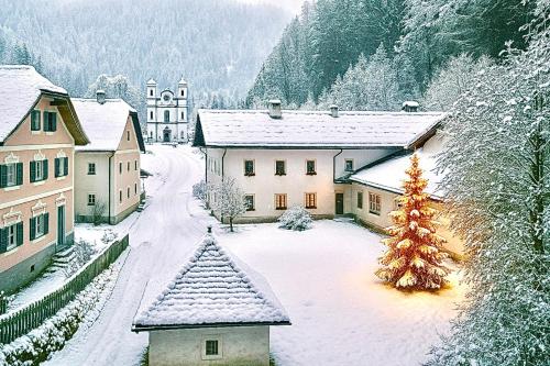 ein schneebedecktes Dorf mit einem Weihnachtsbaum in der Unterkunft Gasthof Maria Kirchental in Sankt Martin bei Lofer