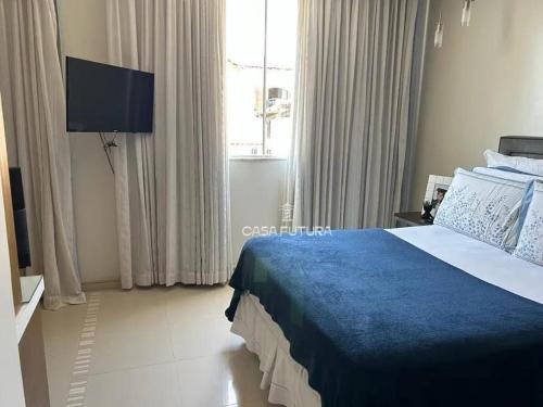 Un dormitorio con una cama grande con una manta azul. en Pousada Lima, en Volta Redonda