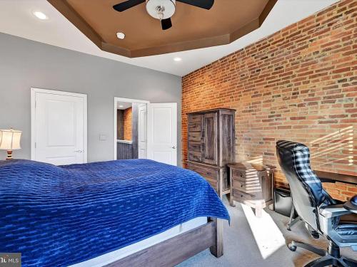 ein Schlafzimmer mit einem Bett und einer Ziegelwand in der Unterkunft Greektown steps from Hopkins in Baltimore