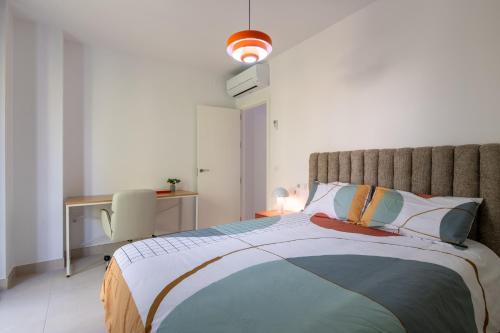 a bedroom with a large bed and a desk at Iberos Home in Seville