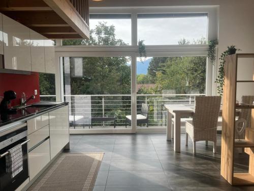 una cucina con un tavolo e una grande finestra di Loft lumineux et confortable a Grimisuat