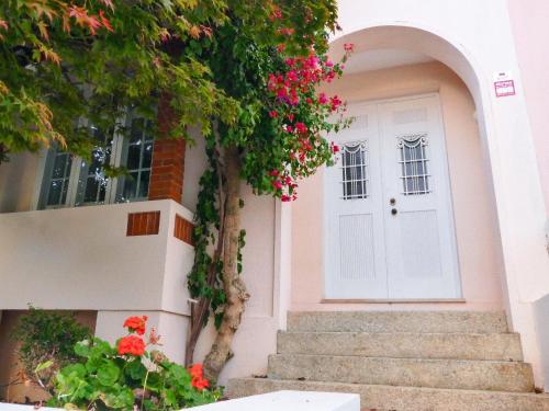 een witte deur van een huis met rode bloemen bij Porto Surf Lodge in Porto