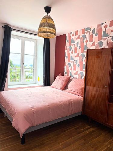 a bedroom with a bed with pink sheets and a window at Vinyle club-rétro 70's-6 pers-Terrasse-Wifi-Parking in Bellême