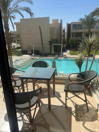 a table and chairs next to a swimming pool at Serenity Studio in G-Cribs in El Gouna