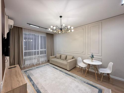 een woonkamer met een bank en een tafel bij Everest Home in Alma-Ata