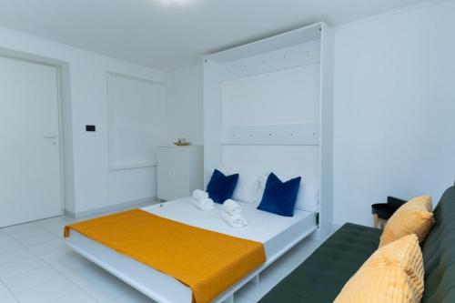 Promo Natale, Esclusiva Struttura Fronte Mare, Vicino al Centro Città في بيسكارا: غرفة نوم بيضاء مع سرير ووسائد زرقاء