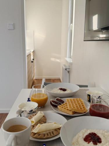 een tafel met daarop borden met eten en kopjes koffie bij Katariina Apartments in Kotka