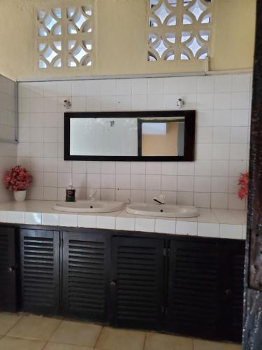 ein Badezimmer mit zwei Waschbecken und einem Spiegel in der Unterkunft Kivuli Holiday Homes Limited in Galu