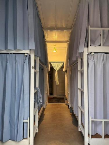 a hallway with blue curtains and bunk beds at Cong Sen Backpackers Hostel in Taitung City