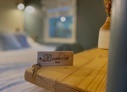 a wooden table with a sign on top of a bed at Cornwall Shepherds Hut - Hot Tub & Cosy Log Burner in Saint Day