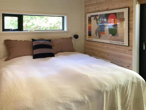 a bedroom with a large white bed with a window at Elegant New Cottage On Quiet Woodland Site in Nykøbing Sjælland
