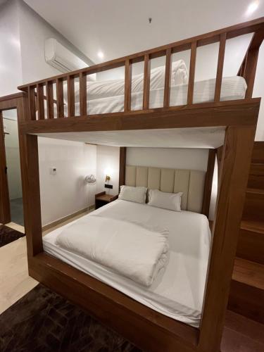 ニューデリーにあるKonnect Inn-New Delhi Railway Stationのベッドルーム1室(白いシーツが備わる二段ベッド2組付)