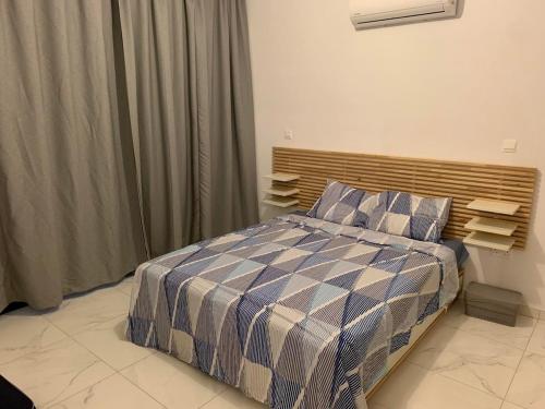 a bedroom with a bed with a blue and white comforter at Fall In Paradise in Paralimni