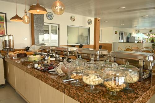 ein Buffet mit vielen Gerichten und Schüsseln. in der Unterkunft Pousada Shalom Beach in Maragogi