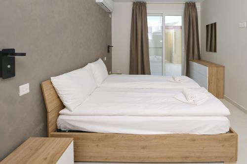 Un dormitorio con una cama grande con sábanas blancas. en Quaint, Central Ground floor 2 Bed 2 Bath apartments at Little Oaks, en Pembroke