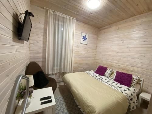 une chambre avec un lit et une télévision dans l'établissement Затишний будинок в передмісті Києва, à Kriukivshchyna