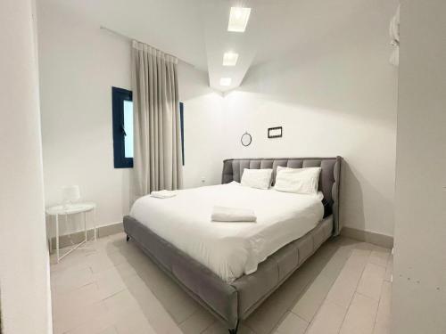 una habitación con una cama grande con sábanas y almohadas blancas en 2Bedroom Suite 7 with shelter, en Tel Aviv
