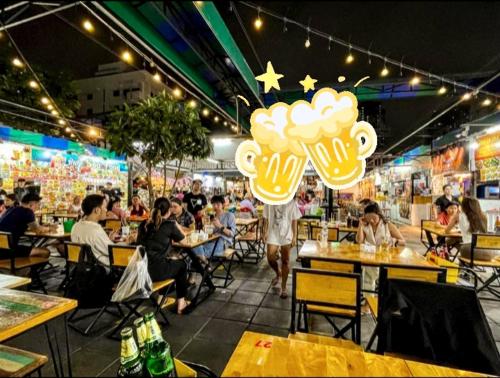 un gruppo di persone sedute ai tavoli di un ristorante di Guesthouse Bangkok BM B&B a Bangkok