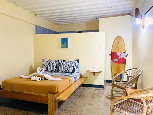 a bedroom with a bed and a surfboard in it at Lexias Hostel and Workspace - Siargao in Catagnan