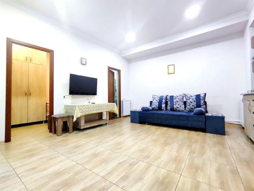 Una sala de estar con un sofá azul y un televisor en Jermuk Mini Apartment, en Jermuk