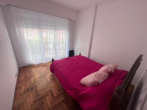 a bedroom with a red bed and a window at 2 Ambientes Gascon in Mar del Plata