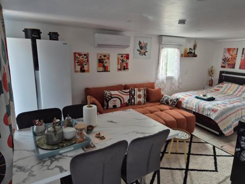 Le Cosy chic في Saint-Maurice-de-Beynost: غرفة معيشة بها طاولة وأريكة وسرير