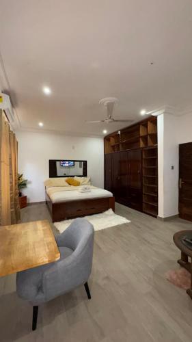 ein großes Schlafzimmer mit einem Bett und einem Stuhl in der Unterkunft Adonai house - Kevat homes in Accra